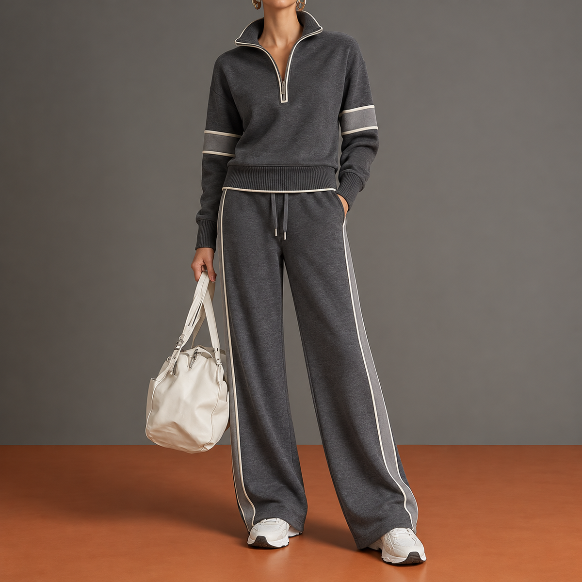 Marietta Profilo in grigio antracite: maglia con mezza zip, bande tonali bordate avorio e pantalone ampio.
