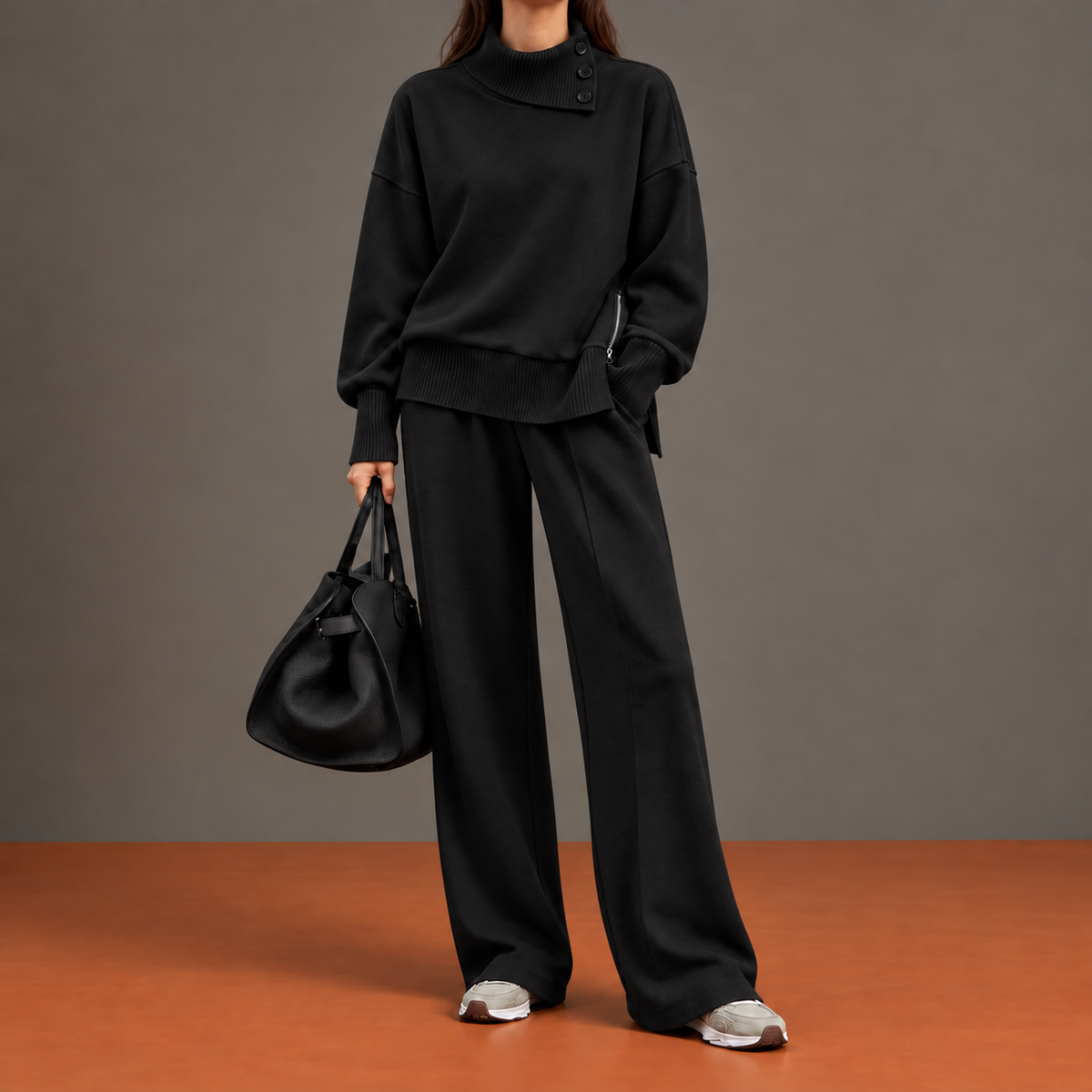 Serena Risvolto nero: completo con collo a bottoni, zip laterale al fondo e pantalone ampio.